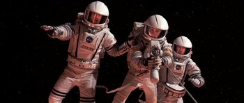 Movie still from “Mission to Mars” (2000), directed by Brian De Palma – Two men in spacesuits are standing in front of a black background; Medium shot, Overhead angle