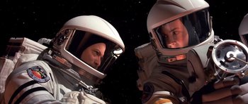 Movie still from “Mission to Mars” (2000), directed by Brian De Palma – Two people in spacesuits in a space station; Close Up shot, Overhead angle