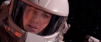 Movie still from “Mission to Mars” (2000), directed by Brian De Palma – A woman wearing a white helmet looking at the camera; Close Up shot, Over the shoulder angle