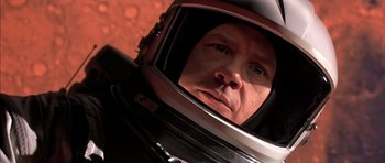 Movie still from “Mission to Mars” (2000), directed by Brian De Palma – A person wearing a space helmet; Close Up shot, Overhead angle