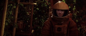 Movie still from “Mission to Mars” (2000), directed by Brian De Palma – A woman in a space suit is standing in a forest; Medium shot, Over the shoulder angle