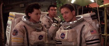 Movie still from “Mission to Mars” (2000), directed by Brian De Palma – A group of people in space suits posing for a picture; Medium shot, Low angle