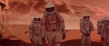 Movie still from “Mission to Mars” (2000), directed by Brian De Palma – Two people in spacesuits walking on a red planet; Wide shot, Low angle