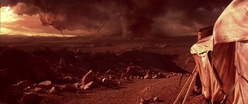 Movie still from “Mission to Mars” (2000), directed by Brian De Palma – A desert landscape with rocks and a dark sky; Extreme Wide shot, High angle