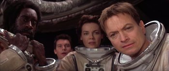 Movie still from “Mission to Mars” (2000), directed by Brian De Palma – A group of people standing next to each other in a room; Close Up shot, Over the shoulder angle