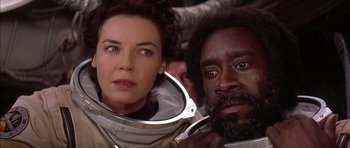 Movie still from “Mission to Mars” (2000), directed by Brian De Palma – A woman standing next to a man in a spacesuit; Close Up shot, Low angle