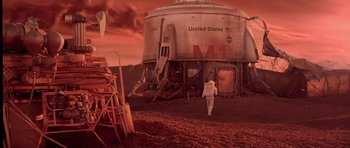 Movie still from “Mission to Mars” (2000), directed by Brian De Palma – A man in a spacesuit walking in front of an abandoned space station; Extreme Wide shot, High angle