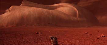 Movie still from “Mission to Mars” (2000), directed by Brian De Palma – An image of a desert scene with a person standing in the middle of the desert; Extreme Wide shot, Overhead angle