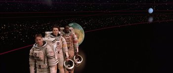 Movie still from “Mission to Mars” (2000), directed by Brian De Palma – A couple of people standing next to each other in spacesuits; Wide shot, Overhead angle