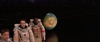 Movie still from “Mission to Mars” (2000), directed by Brian De Palma – An image of a man in a spacesuit in front of an earth; Medium shot, Overhead angle