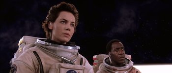 Movie still from “Mission to Mars” (2000), directed by Brian De Palma – A woman and a man in spacesuits are standing in the dark; Close Up shot, Low angle