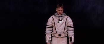 Movie still from “Mission to Mars” (2000), directed by Brian De Palma – A man in a spacesuit standing in front of a black background; Medium shot, Low angle