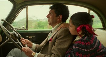 Movie still from “Mississippi Masala” (1991), directed by Mira Nair – A man and a young girl sitting in the back seat of a car; Medium shot, Low angle