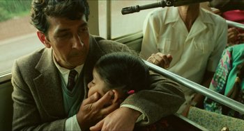 Movie still from “Mississippi Masala” (1991), directed by Mira Nair – A man and a child on a train; Close Up shot, Low angle