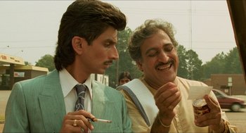 Movie still from “Mississippi Masala” (1991), directed by Mira Nair – Two men in suits and ties are smoking a cigarette; Close Up shot, Low angle