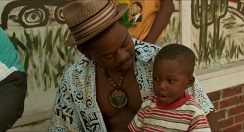 Movie still from “Mississippi Masala” (1991), directed by Mira Nair – A man and a boy are standing next to each other; Close Up shot, Over the shoulder angle