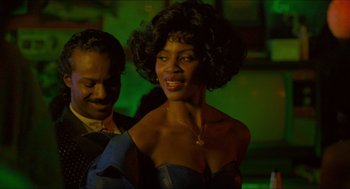 Movie still from “Mississippi Masala” (1991), directed by Mira Nair – A man and a woman are standing in a green room; Close Up shot, Low angle