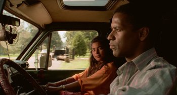 Movie still from “Mississippi Masala” (1991), directed by Mira Nair – A man and a woman riding in the back of a car; Close Up shot, Low angle