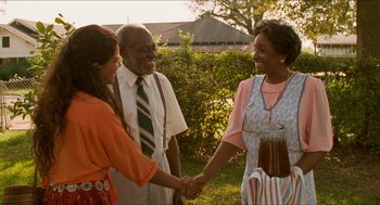 Movie still from “Mississippi Masala” (1991), directed by Mira Nair – Two women and an older man are shaking hands; Medium shot, Over the shoulder angle