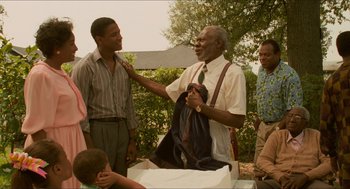 Movie still from “Mississippi Masala” (1991), directed by Mira Nair – A man in a white dress shirt and a green tie; Medium shot, Over the shoulder angle