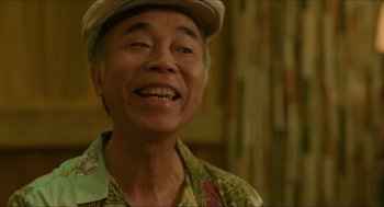 Movie still from “Mississippi Masala” (1991), directed by Mira Nair – An older man wearing a hat and smiling for the camera; Close Up shot, Low angle