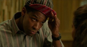 Movie still from “Mississippi Masala” (1991), directed by Mira Nair – A young man with a striped cap is holding his hand to his head; Close Up shot, Low angle