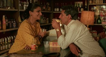Movie still from “Mississippi Masala” (1991), directed by Mira Nair – A man and a woman sitting at a table; Medium shot, Low angle