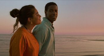Movie still from “Mississippi Masala” (1991), directed by Mira Nair – A man and a woman standing next to a body of water; Medium shot, Low angle