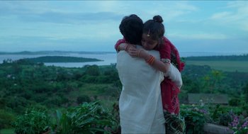 Movie still from “Mississippi Masala” (1991), directed by Mira Nair – A man and a girl hug on top of a hill; Medium shot, Low angle