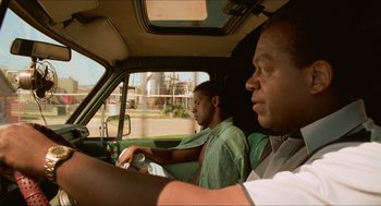 Movie still from “Mississippi Masala” (1991), directed by Mira Nair – Two men are driving in a car in the road; Close Up shot, Low angle