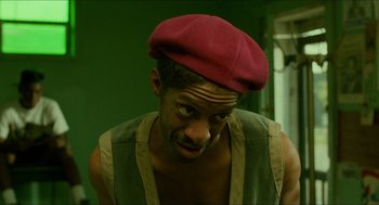 Movie still from “Mississippi Masala” (1991), directed by Mira Nair – A man wearing a red hat and a green shirt; Close Up shot, Low angle