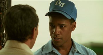 Movie still from “Mississippi Masala” (1991), directed by Mira Nair – A man wearing a hat talking to another man; Close Up shot, Over the shoulder angle