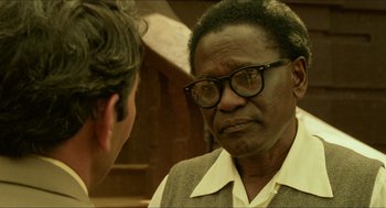 Movie still from “Mississippi Masala” (1991), directed by Mira Nair – An older man wearing glasses talking to a younger man; Close Up shot, Over the shoulder angle