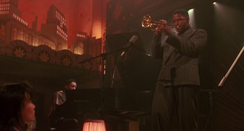 Movie still from “Mo' Better Blues” (1990), directed by Spike Lee – A man playing a trumpet in front of an audience; Medium shot, Low angle