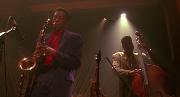 Movie still from “Mo' Better Blues” (1990), directed by Spike Lee – Two men in suits playing instruments on a stage; Medium shot, Low angle