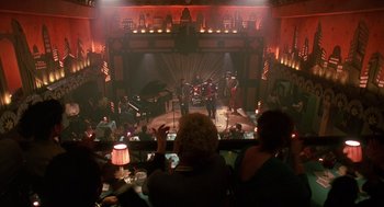 Movie still from “Mo' Better Blues” (1990), directed by Spike Lee – A group of people sitting at tables in front of a stage; Extreme Wide shot, High angle