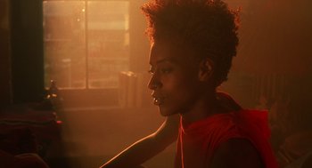 Movie still from “Mo' Better Blues” (1990), directed by Spike Lee – A woman in a red shirt is looking out a window; Close Up shot, Over the shoulder angle