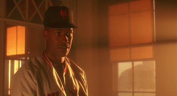 Movie still from “Mo' Better Blues” (1990), directed by Spike Lee – A baseball player is standing in the sunlight; Close Up shot, Low angle