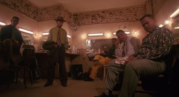 Movie still from “Mo' Better Blues” (1990), directed by Spike Lee – Two men are sitting in a living room; Wide shot, Low angle
