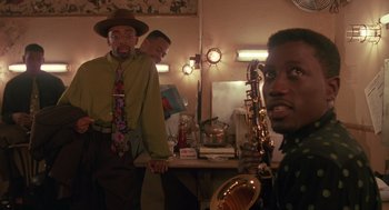 Movie still from “Mo' Better Blues” (1990), directed by Spike Lee – A group of men standing next to each other in a room; Medium shot, Low angle