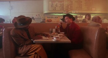 Movie still from “Mo' Better Blues” (1990), directed by Spike Lee – Two men sitting at a table in front of a menu; Medium shot, Low angle