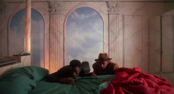 Movie still from “Mo' Better Blues” (1990), directed by Spike Lee – Two men are laying on a bed in front of an archway; Medium shot, Low angle