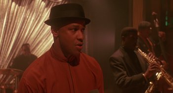 Movie still from “Mo' Better Blues” (1990), directed by Spike Lee – A man wearing a red shirt and a black hat; Close Up shot, Low angle