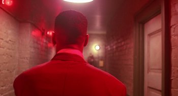 Movie still from “Mo' Better Blues” (1990), directed by Spike Lee – A man in a red suit standing in a dark room; Close Up shot, Low angle