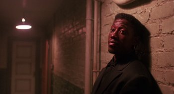 Movie still from “Mo' Better Blues” (1990), directed by Spike Lee – A man in a black suit standing next to a brick wall; Close Up shot, Low angle