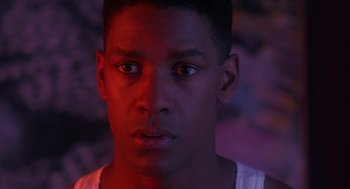 Movie still from “Mo' Better Blues” (1990), directed by Spike Lee – A young man is looking into the camera; Close Up shot, Over the shoulder angle