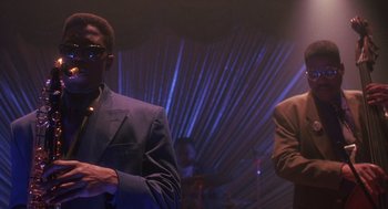 Movie still from “Mo' Better Blues” (1990), directed by Spike Lee – A man in a suit standing next to another man in a suit; Medium shot, Low angle