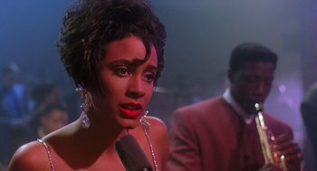 Movie still from “Mo' Better Blues” (1990), directed by Spike Lee – A woman with red lipstick is talking into a microphone; Close Up shot, Over the shoulder angle