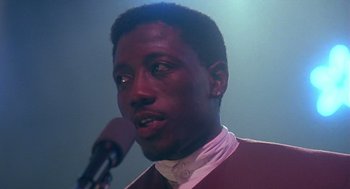 Movie still from “Mo' Better Blues” (1990), directed by Spike Lee – A person speaking on a microphone; Close Up shot, Low angle