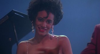Movie still from “Mo' Better Blues” (1990), directed by Spike Lee – A woman in a strapless dress with dangling earrings; Close Up shot, Over the shoulder angle